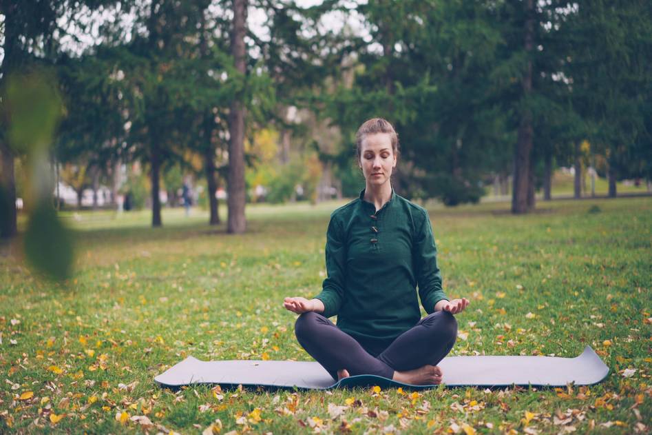 Serene woman practicing weight loss hypnosis meditation in calm nature setting